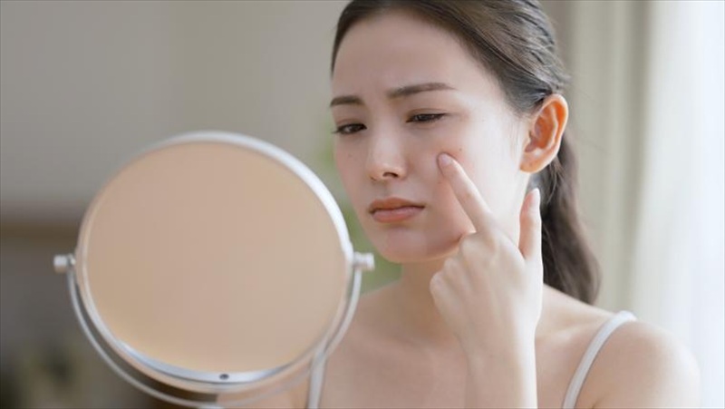 鏡を見て落ち込む女性